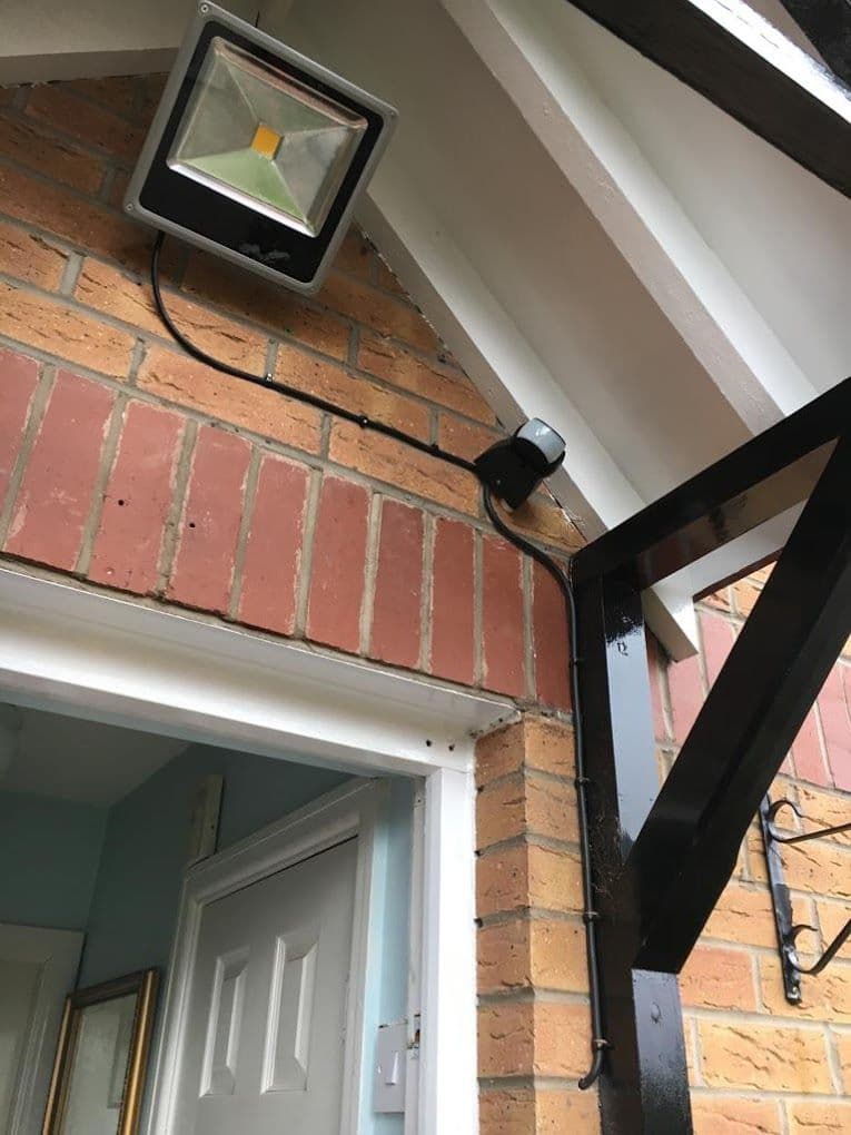 Security floodlight and PIR sensor above a doorway